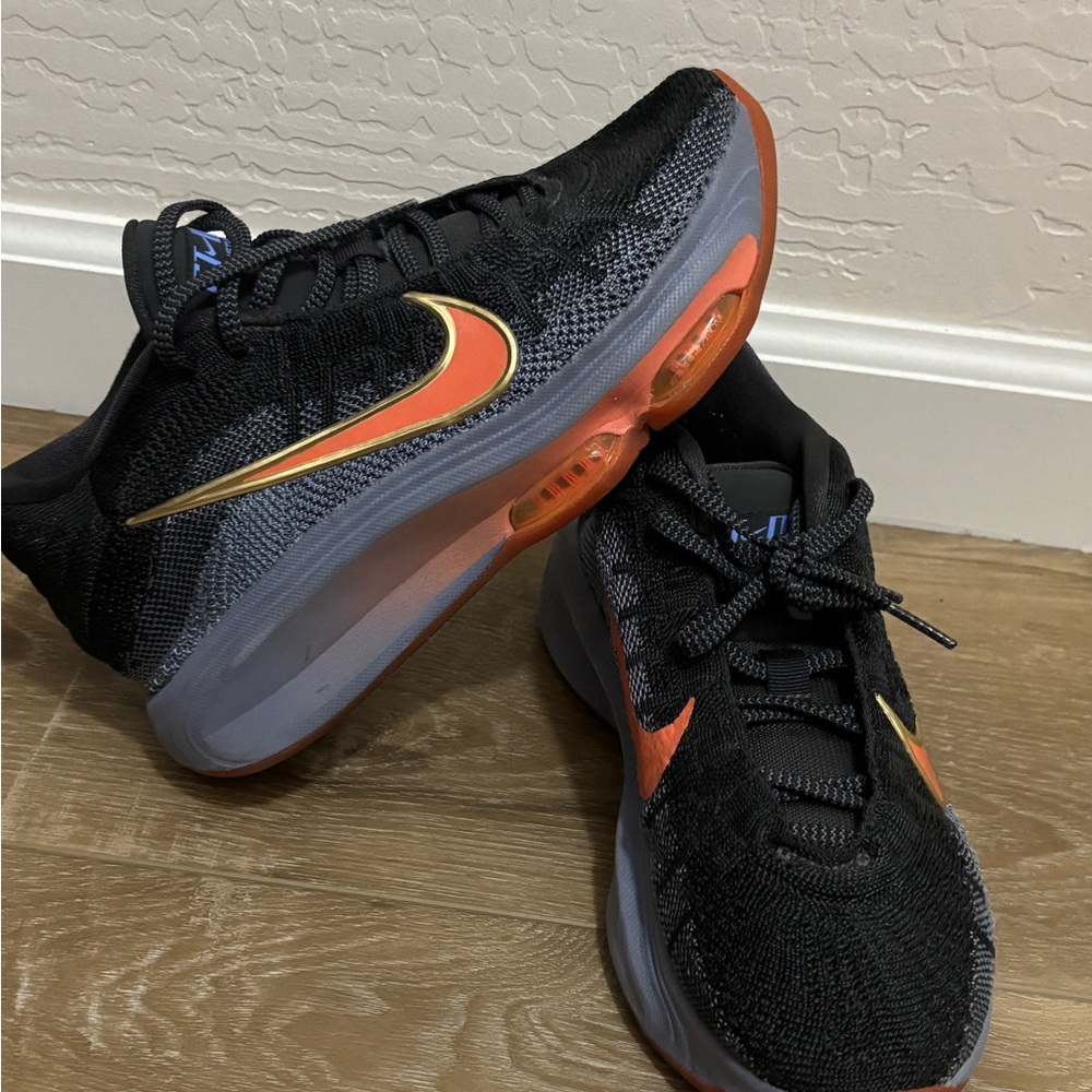 Nike Black Low-Top Sneakers with Orange & Gold Swoosh. Court shoes.